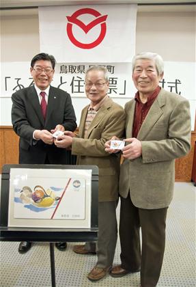 2月22日の交付式で、日野町出身の2人にカードを進呈する景山享弘町長