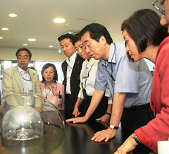 菅直人前総理ら国会議員がナトリウムの実験装置を見つめる