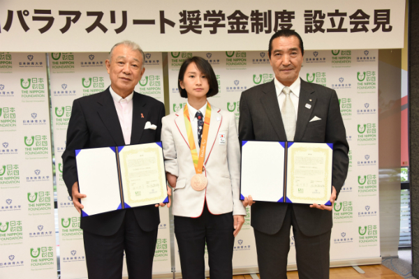 署名した覚書を示す松浪日体大理事長（右）と笹川日本財団会長、中央が辻選手