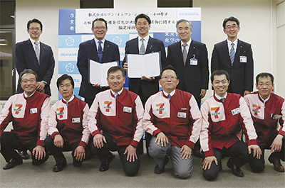 協定書を持つ加藤市長（後列中央）と（株）セブン‐イレブン・ジャパンの百瀬神奈川ゾーンマネジャー（市長左）。前列は市内のセブン‐イレブンオーナー