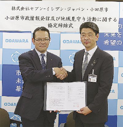 協定書を持ち、固い握手を交わす加藤市長（右）と百瀬神奈川マネジャー